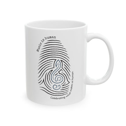 A white ceramic mug featuring a black and blue graphic of a fingerprint and treble clef with the text 'Music is human' and 'Celebrating what makes us human'.