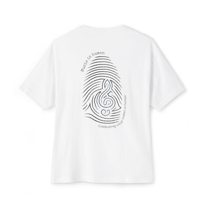 A white short-sleeve t-shirt shown from the back, featuring a black graphic of a fingerprint and musical notes with the text 'Music is human' and 'Celebrating what makes us human'.