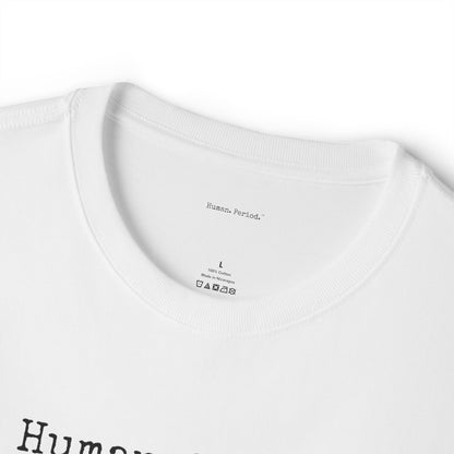 Close-up of a white crewneck t-shirt showing the inner neck label with 'Human Period.' printed inside, along with size 'L' and care instructions, with a black graphic print partially visible at the bottom.