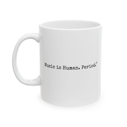 A white ceramic coffee mug with the printed text 'Music is Human. Period.