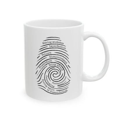 A white ceramic mug with a black printed graphic of a spiral fingerprint made of words like 'failure', 'disappointment', and 'perseverance' on a clean white background.