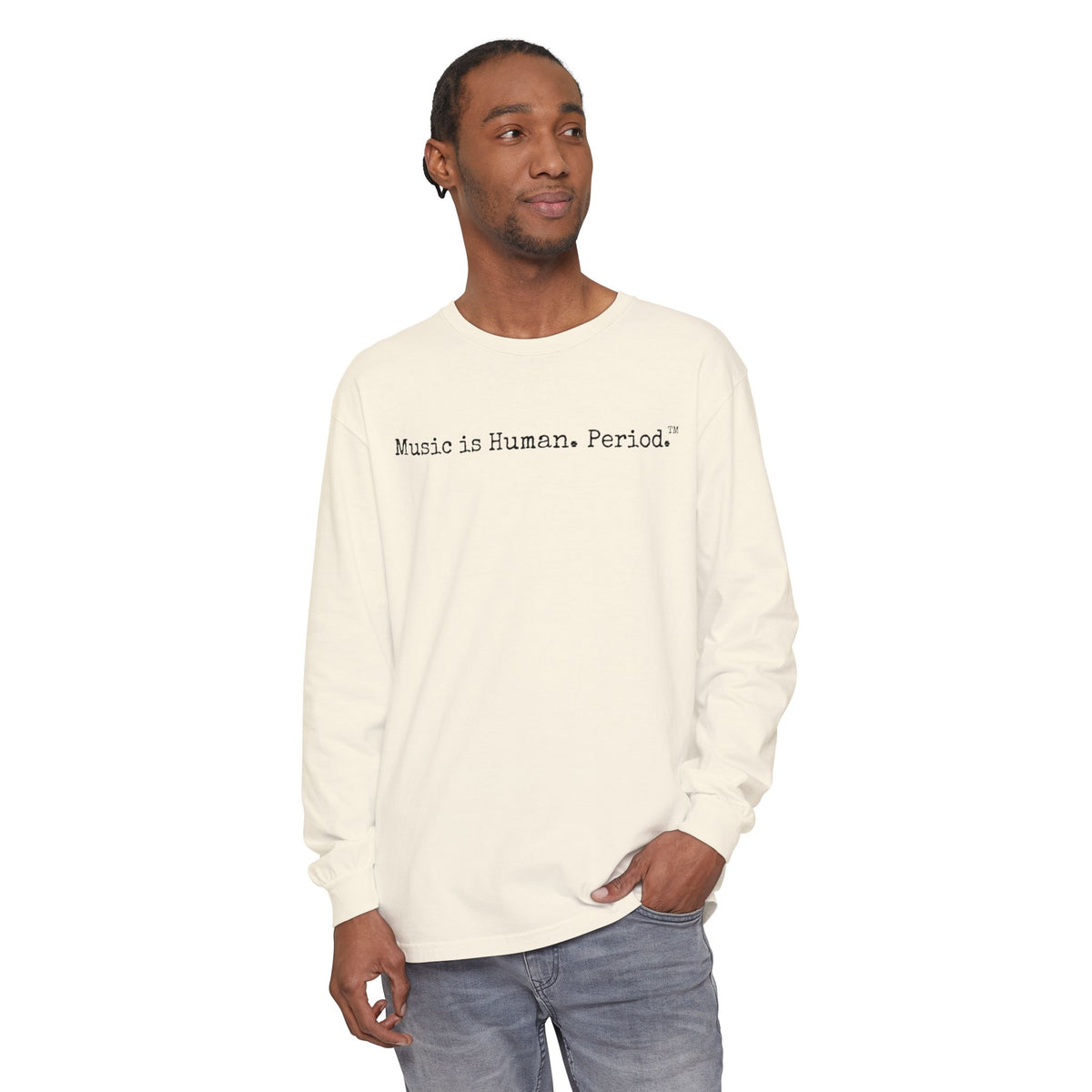 Man wearing cream long-sleeve shirt with text "Music is Human.Period" in clean type-writer font on white background.