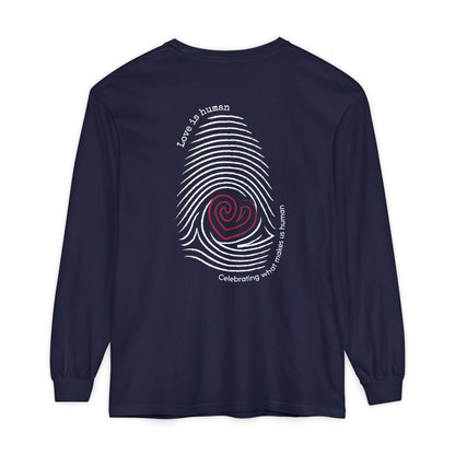 A navy long-sleeve t-shirt with a graphic on the back featuring a white fingerprint pattern, a red heart in the center, and white text that reads 'Love is human' and 'Celebrating what makes us human'.