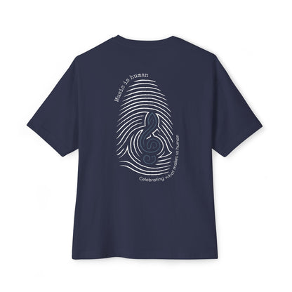 A navy blue short-sleeve t-shirt shown from the back, featuring a white graphic print of a fingerprint and treble clef with the text 'Music is human' and 'Celebrating what makes us human.'