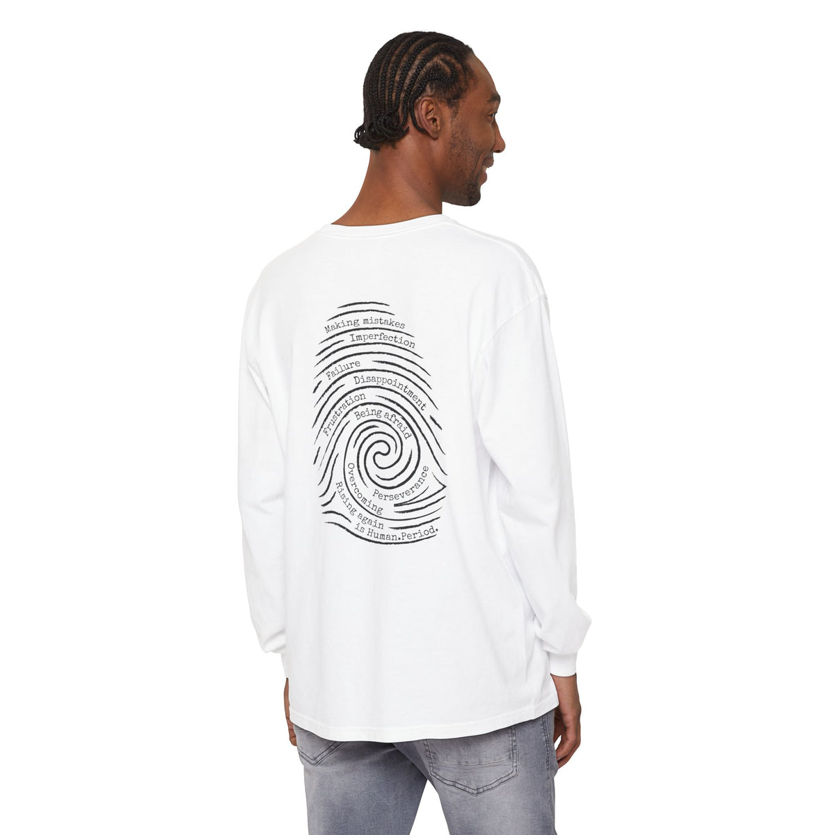 Man wearing a  white  long-sleeve t-shirt with a graphic print of a spiral fingerprint on the back, set against a plain white background. Words like failure, making mistakes, perseverance and overcoming fill the spiral. 