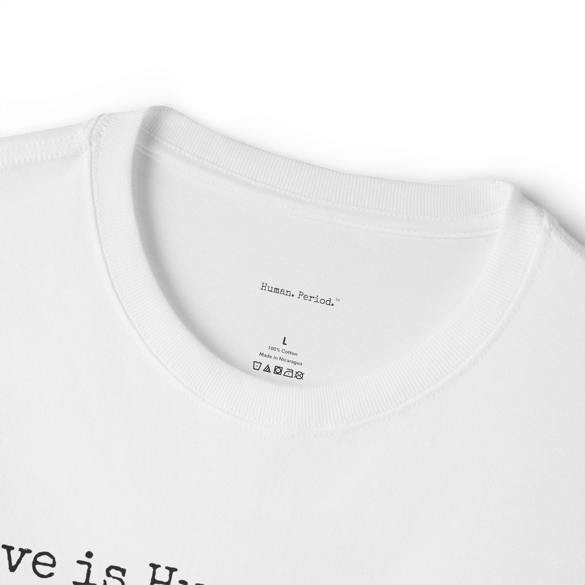 Close-up of a white crewneck t-shirt showing the inner collar label with 'Human Period.' printed inside, size L, and part of a black graphic text at the bottom left.