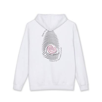 A white pullover hoodie shown from the back, featuring a large graphic print of a black fingerprint with a red spiral heart in the center and curved black text around it. "Love is human"