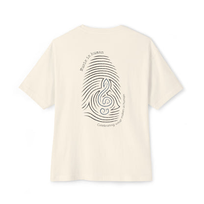 An off-white short-sleeve t-shirt shown from the back, featuring a black graphic of a fingerprint and musical notes with the text 'Music is human' and 'Celebrating what makes us human'.