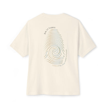 A cream short-sleeve t-shirt shown from the back, featuring a large graphic print of a spiral fingerprint in a multi gradient with the text 'Art Is human' and 'Celebrating what makes us human'.