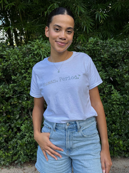 A woman wearing a white graphic t-shirt with the text 'Human. Period.