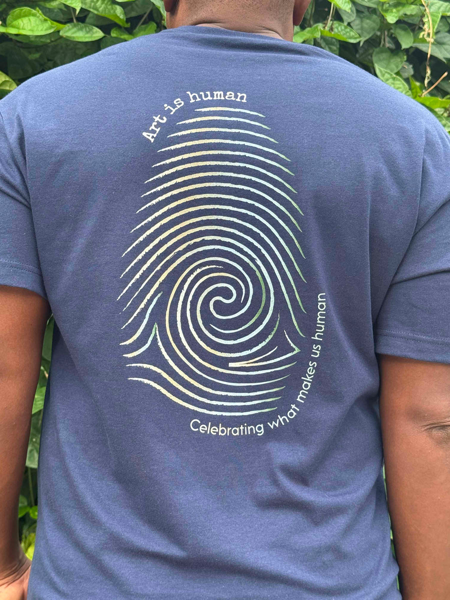 Dark blue shirt with Art is human and celebrating what makes us human text with a color gradient finger print.